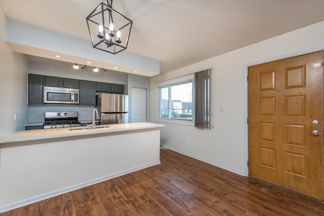 kitchen with sink, decorative light fixtures, kitchen peninsula, and appliances with stainless steel finishes