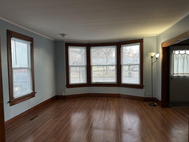 empty room featuring crown molding and dark hardwood / wood-style floors