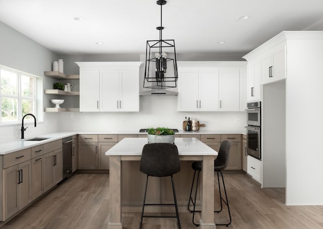 kitchen with sink, white cabinetry, a center island, and hardwood / wood-style floors