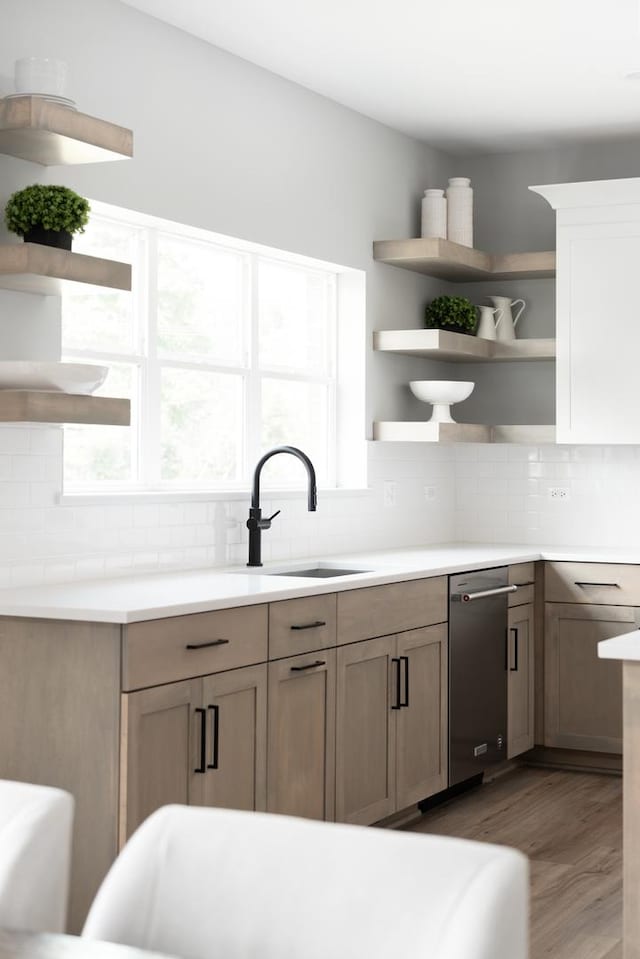 kitchen with sink, light hardwood / wood-style floors, and decorative backsplash