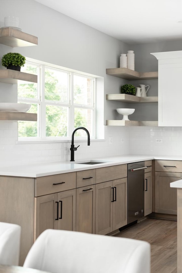 kitchen featuring light brown cabinetry, sink, light hardwood / wood-style flooring, and tasteful backsplash