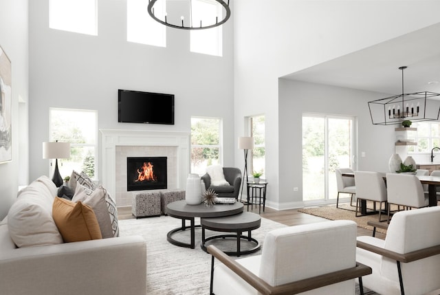 living room featuring a chandelier, light hardwood / wood-style flooring, and a high ceiling