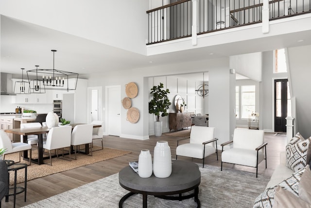 living room with hardwood / wood-style floors, a towering ceiling, and a notable chandelier