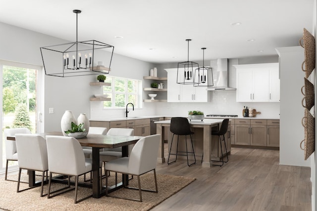 dining room featuring sink, hardwood / wood-style flooring, a notable chandelier, and plenty of natural light