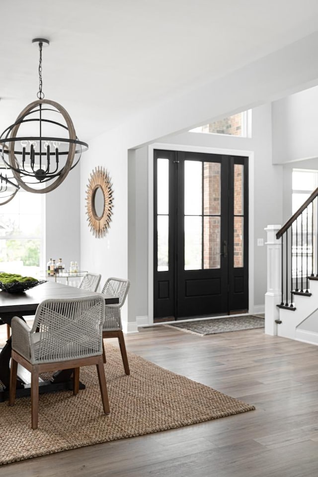 foyer entrance with a notable chandelier and hardwood / wood-style flooring