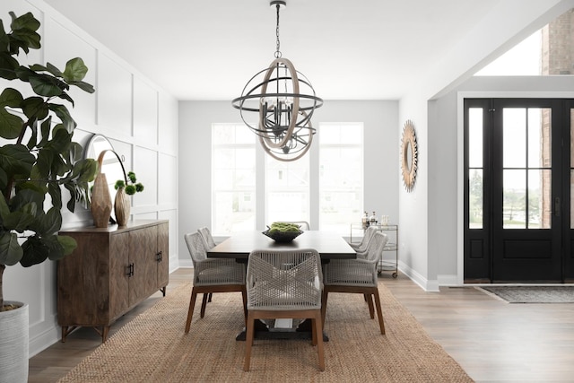 dining room featuring a wealth of natural light, an inviting chandelier, and light hardwood / wood-style floors