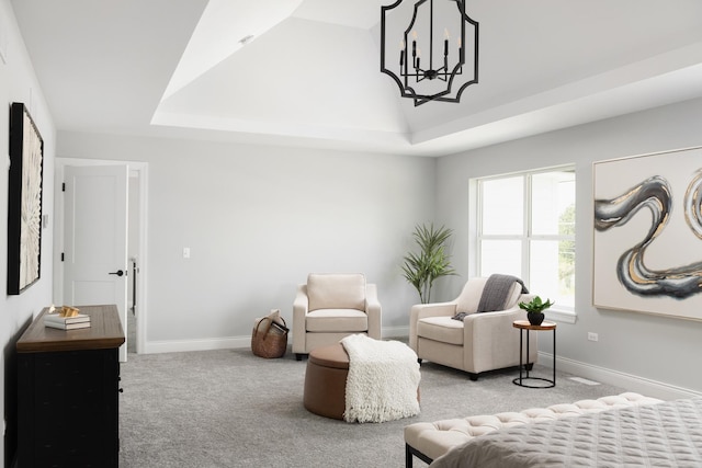 living area featuring a chandelier, light colored carpet, and a tray ceiling