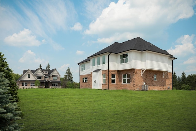 rear view of house with central air condition unit and a lawn