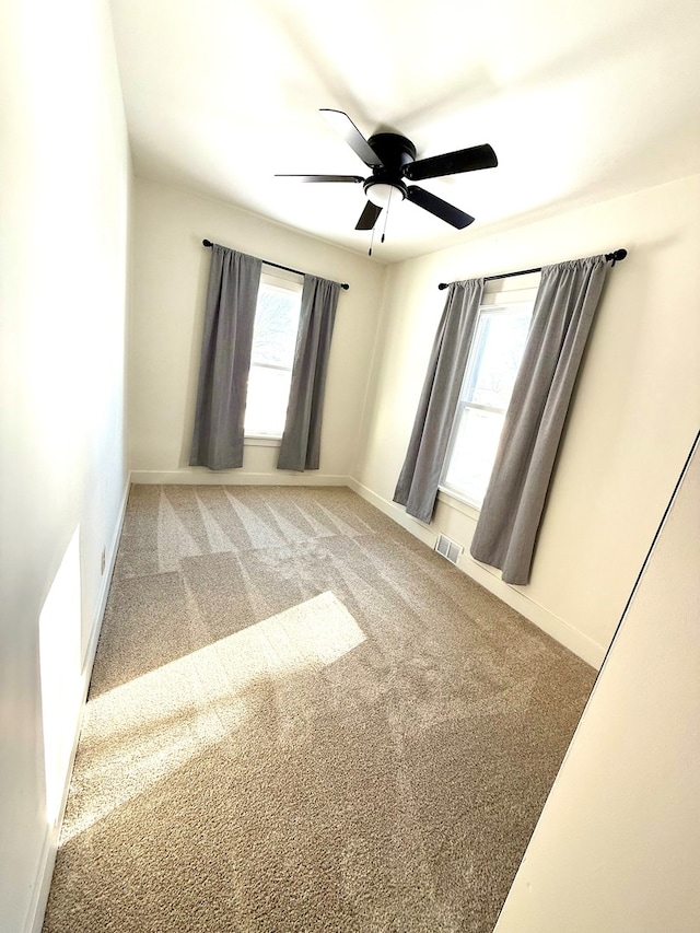 carpeted empty room featuring ceiling fan