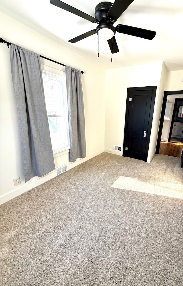 unfurnished bedroom with ceiling fan and carpet