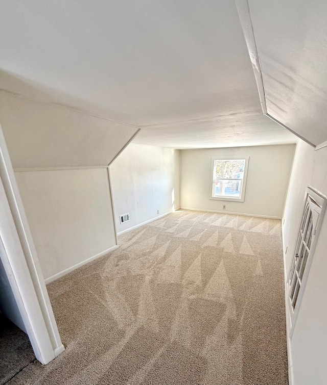 additional living space with vaulted ceiling and carpet floors