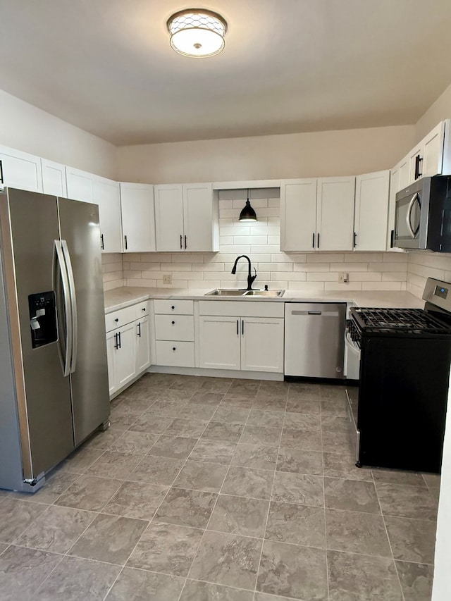 kitchen featuring backsplash, sink, white cabinetry, hanging light fixtures, and stainless steel appliances