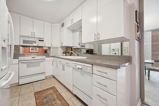 kitchen featuring white cabinets, light tile patterned floors, white appliances, and sink