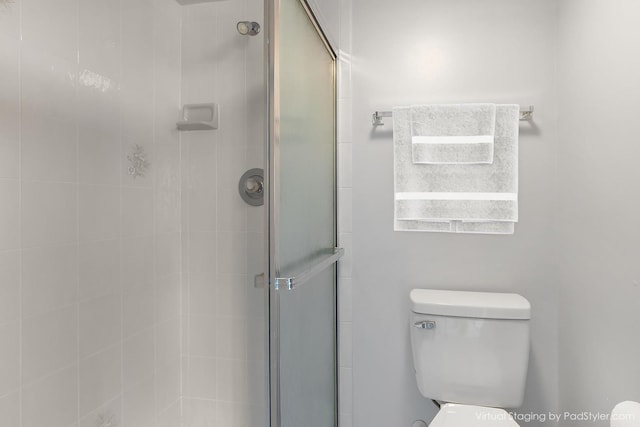 bathroom with a shower with shower door and toilet