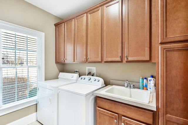 washroom with cabinets, washing machine and dryer, sink, and a healthy amount of sunlight