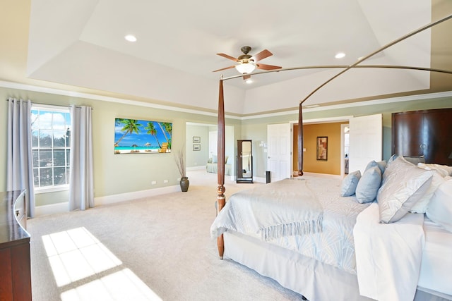 carpeted bedroom with a tray ceiling and ceiling fan