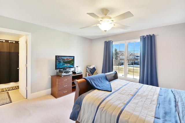 bedroom with connected bathroom, light carpet, and ceiling fan