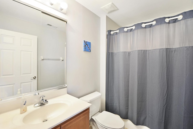 bathroom featuring vanity, walk in shower, and toilet