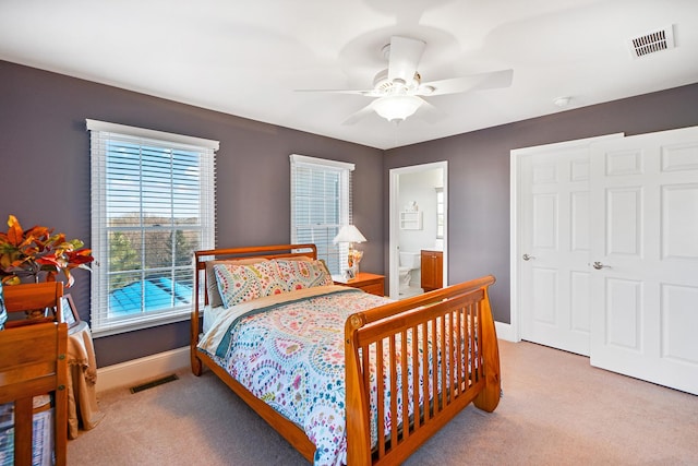 carpeted bedroom with ceiling fan and ensuite bath