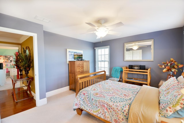 carpeted bedroom featuring ceiling fan and ornamental molding