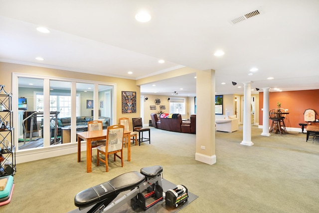 interior space featuring light colored carpet, ornamental molding, and decorative columns