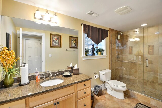 bathroom featuring vanity, tile patterned floors, a shower with door, and toilet