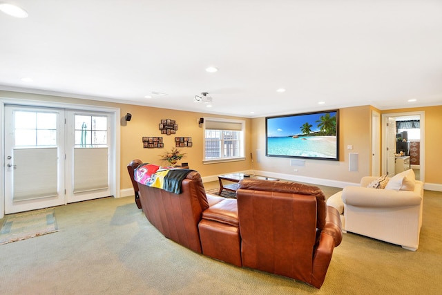 home theater room with light colored carpet, ornamental molding, and a wealth of natural light