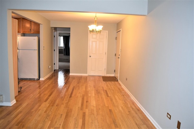 unfurnished dining area featuring a chandelier, light hardwood / wood-style floors, and baseboard heating