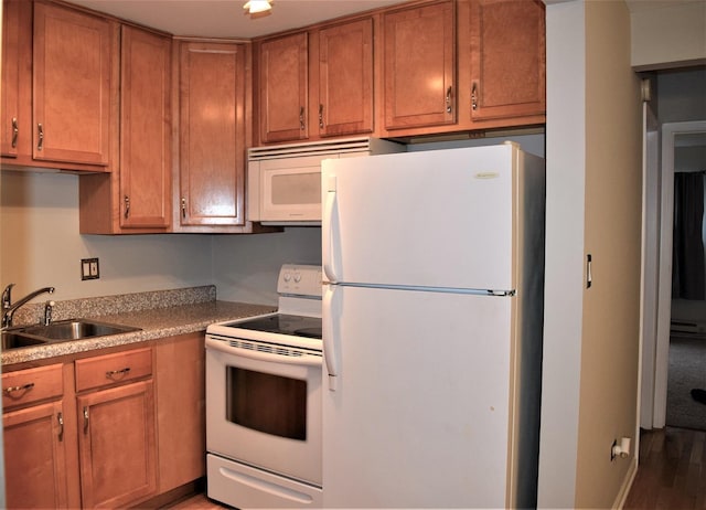 kitchen with white appliances, dark hardwood / wood-style floors, and sink