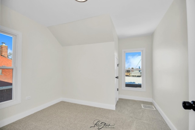 unfurnished room with light carpet and vaulted ceiling