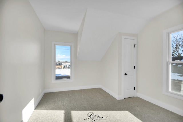 additional living space with light colored carpet and vaulted ceiling