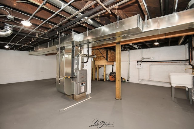 basement featuring heating unit and sink