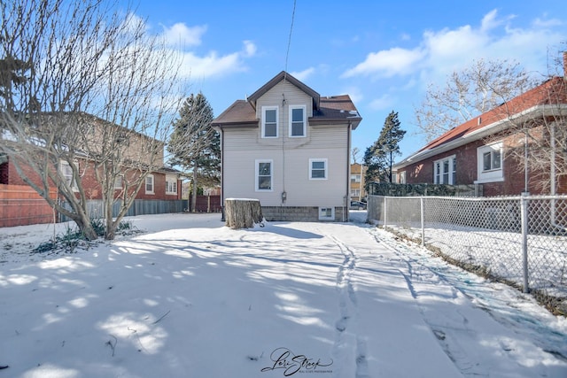 view of snow covered rear of property