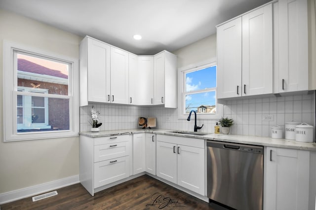 kitchen featuring white cabinets, sink, stainless steel dishwasher, dark hardwood / wood-style floors, and light stone countertops