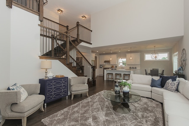 living room featuring a high ceiling, dark hardwood / wood-style flooring, and sink