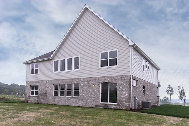 rear view of house featuring a yard and cooling unit