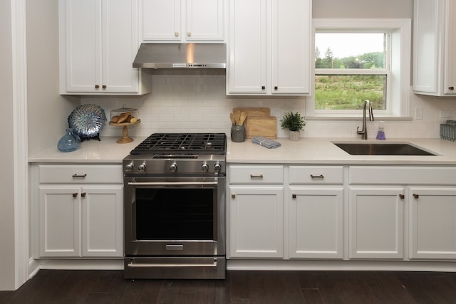 kitchen featuring stainless steel range with gas stovetop, backsplash, white cabinets, and sink