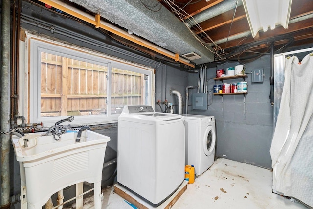 clothes washing area featuring electric panel, independent washer and dryer, and sink