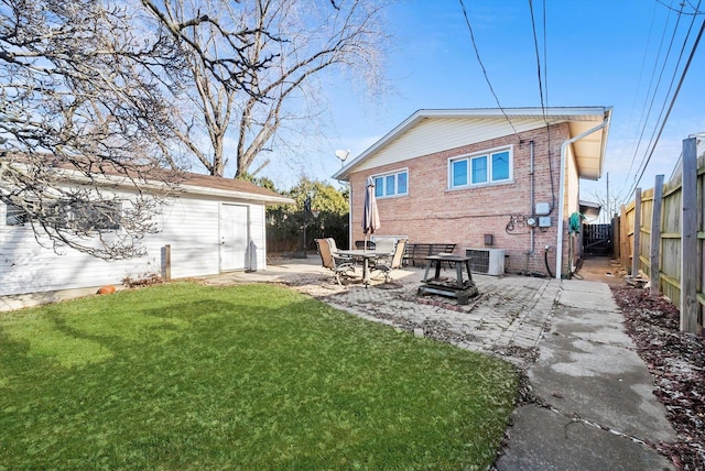 back of property with central AC, a patio area, and a yard