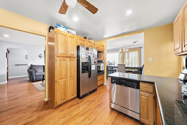 kitchen featuring ceiling fan with notable chandelier, pendant lighting, appliances with stainless steel finishes, light brown cabinets, and light wood-type flooring