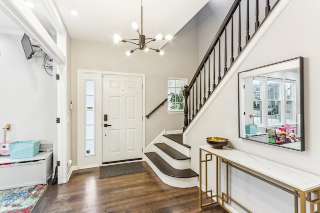 entrance foyer with dark hardwood / wood-style floors, a wealth of natural light, and a chandelier