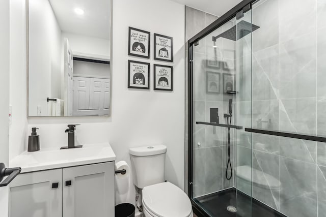 bathroom with vanity, an enclosed shower, and toilet