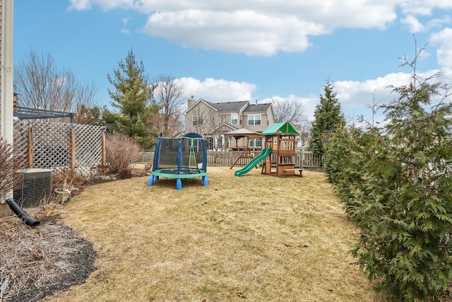 view of playground featuring a trampoline, a lawn, and central air condition unit