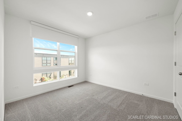 carpeted empty room featuring visible vents and baseboards