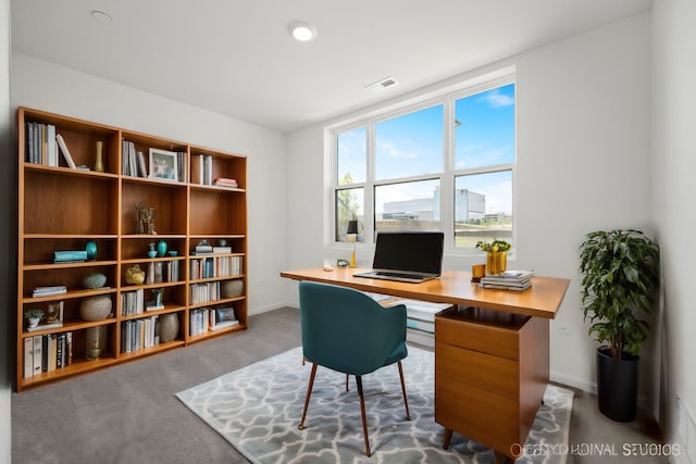 carpeted home office with baseboards and visible vents