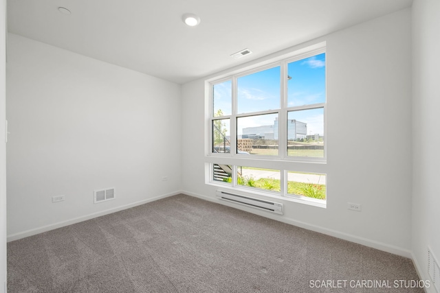 carpeted spare room with baseboard heating, visible vents, and baseboards