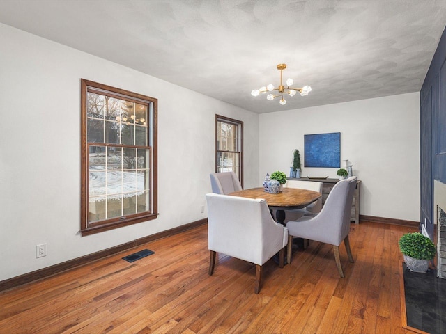 dining room featuring hardwood / wood-style flooring and an inviting chandelier