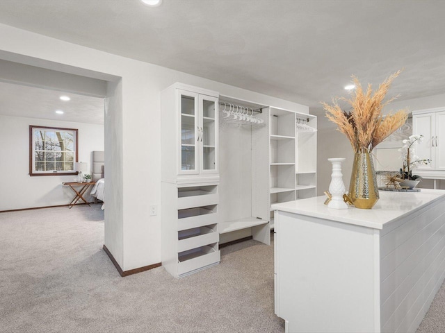 walk in closet featuring light carpet