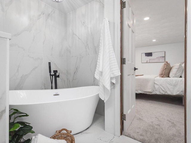 bathroom featuring a bathing tub and tile walls