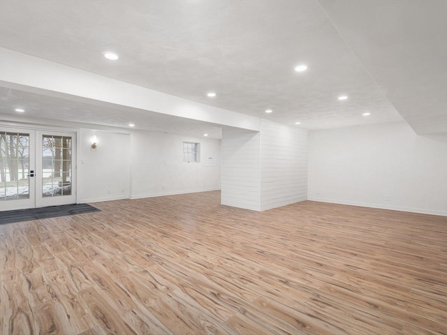 basement with light wood-type flooring and french doors